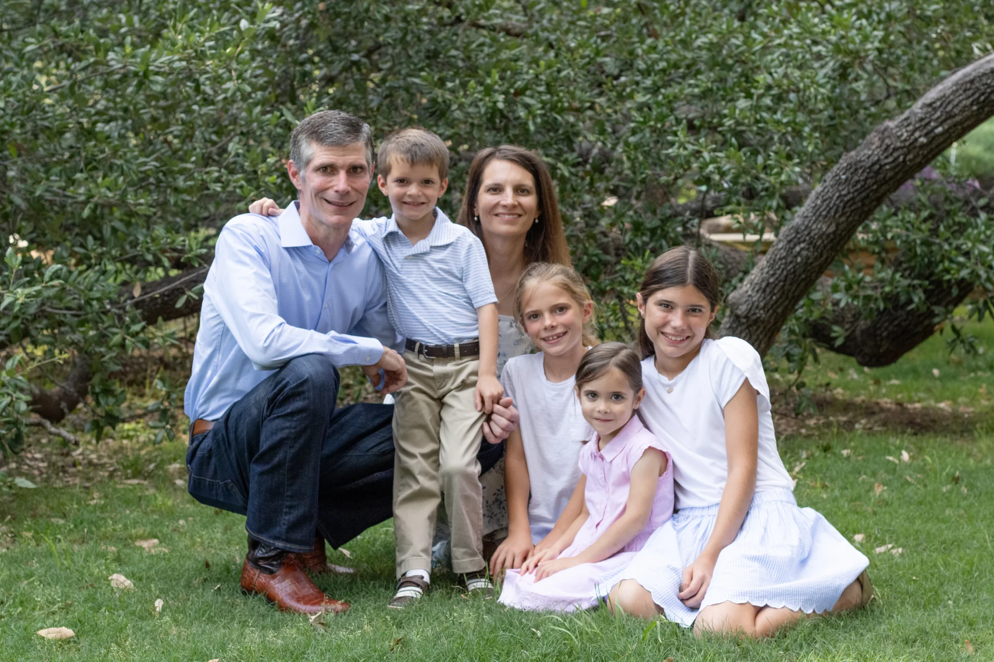 A family gathered together beneath the trees