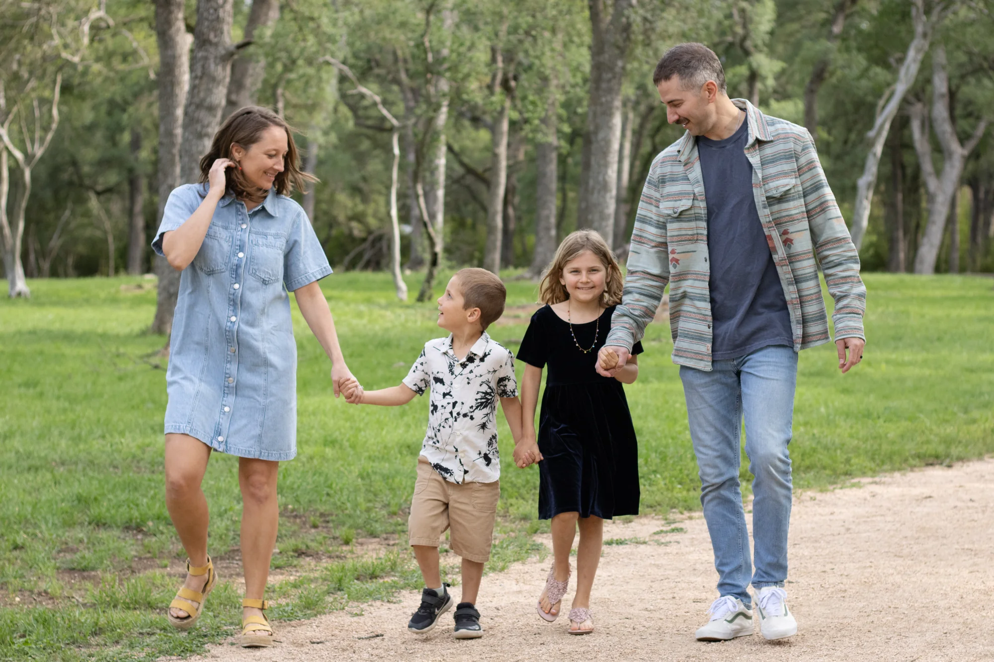 The Harris family walking together through a wooded Austin park